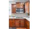 Close up of kitchen with stainless steel microwave, cooktop, stylish cabinets and stone backsplash at 7022 Tamarind Ct, Indianapolis, IN 46236