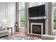 Bright living room features a fireplace, tall windows with patterned curtains, and a decorative rug at 7022 Tamarind Ct, Indianapolis, IN 46236