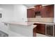 Wet bar with dark cabinets, light countertops, wine rack, and under-counter beverage fridge at 7022 Tamarind Ct, Indianapolis, IN 46236