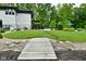 Spacious backyard with a wooden bridge, well-manicured lawn, pool, and seating areas, perfect for outdoor enjoyment at 7070 Dean Rd, Indianapolis, IN 46220