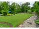 Lush green backyard with well-maintained lawn, mature trees, and a charming stone-lined pathway, creating a serene outdoor space at 7070 Dean Rd, Indianapolis, IN 46220