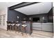 Finished basement bar area features a modern aesthetic, wood bar, and seating next to a living room area at 7070 Dean Rd, Indianapolis, IN 46220