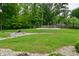 Spacious backyard featuring a basketball court and a charming stone-lined creek, offering both recreation and natural beauty at 7070 Dean Rd, Indianapolis, IN 46220