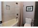 Neat bathroom with a shower, toilet, decorative niche, and tiled walls at 7070 Dean Rd, Indianapolis, IN 46220