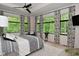 Bright bedroom featuring large windows with lush greenery views and a ceiling fan at 7070 Dean Rd, Indianapolis, IN 46220