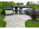 Stunning contemporary home with stone accents, a large driveway, and lush landscaping at 7070 Dean Rd, Indianapolis, IN 46220