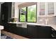 Contemporary kitchen featuring black and white cabinets, quartz countertops, and a stainless steel farmhouse sink at 7070 Dean Rd, Indianapolis, IN 46220