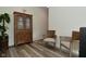 Cozy seating area with a wooden cabinet, chairs, and a potted plant on wood-look flooring at 7070 Dean Rd, Indianapolis, IN 46220