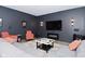 Basement living room featuring a modern sectional, wall-mounted TV, accent chairs, and a colorful area rug at 7070 Dean Rd, Indianapolis, IN 46220