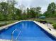 Inviting in-ground pool with clear blue water and poolside seating, surrounded by lush greenery, creating a perfect oasis at 7070 Dean Rd, Indianapolis, IN 46220