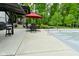 Relaxing poolside patio with comfortable seating under a red umbrella, ideal for lounging and entertaining by the covered pool at 7070 Dean Rd, Indianapolis, IN 46220