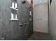 Contemporary shower featuring dual shower heads, built-in shelves, and unique tile work at 7070 Dean Rd, Indianapolis, IN 46220