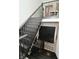 View of staircase with dark wood stairs and black metal railing, and a storage unit at the bottom of the staircase at 7070 Dean Rd, Indianapolis, IN 46220