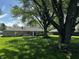 Spacious backyard featuring mature trees, lush green grass, and a patio area perfect for outdoor living at 7127 Lincoln St, Anderson, IN 46013