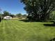 Large backyard showcasing well-maintained lawn, mature trees, and an outdoor structure for leisure at 7127 Lincoln St, Anderson, IN 46013