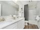 Well-lit bathroom featuring double sinks with white cabinets, a spacious mirror, and a shower-tub combination at 7145 Firestone Rd, Whitestown, IN 46075