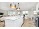 Open concept kitchen with a view of living spaces, a central island, and modern lighting fixtures at 7145 Firestone Rd, Whitestown, IN 46075