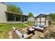 Cozy backyard patio with a stone fireplace, outdoor seating, green lawn, and enclosed sunroom at 7215 Wet Rock Ct, Indianapolis, IN 46236
