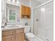 Functional bathroom featuring wood cabinetry, a granite vanity, and a walk-in shower with sliding doors at 7215 Wet Rock Ct, Indianapolis, IN 46236