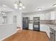 Bright kitchen with white cabinets, stainless steel appliances, and hardwood floors at 7215 Wet Rock Ct, Indianapolis, IN 46236