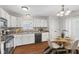 Eat-in kitchen with white cabinets, updated countertops, stainless steel appliances, and a cozy dining area at 7215 Wet Rock Ct, Indianapolis, IN 46236