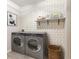 Modern laundry room featuring new front-load washer and dryer units and stylish geometric wallpaper at 7215 Wet Rock Ct, Indianapolis, IN 46236