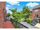 Balcony view of street and red brick townhomes with black shutters on a sunny day at 73 11Th Nw St, Carmel, IN 46032