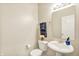 Powder room featuring a pedestal sink, toilet, and decorative flower arrangement at 73 11Th Nw St, Carmel, IN 46032