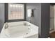 Modern bathroom featuring a large soaking tub with glass block window and a shower stall at 73 11Th Nw St, Carmel, IN 46032