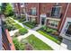 Brick townhome exterior featuring manicured landscaping and black accents on a sunny day at 73 11Th Nw St, Carmel, IN 46032