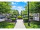 A path leading to a townhome community with trees, sidewalks, and a grassy green space at 73 11Th Nw St, Carmel, IN 46032