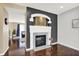 Stylish fireplace featuring a white mantle and hearth, set against a dark wall with hardwood floors and natural light at 73 11Th Nw St, Carmel, IN 46032