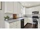 Charming kitchen featuring white cabinets, hardwood floors, and ample counter space under a bright window at 73 11Th Nw St, Carmel, IN 46032