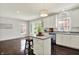 Spacious kitchen with white cabinets, a kitchen island, hardwood floors, and abundant natural light from surrounding windows at 73 11Th Nw St, Carmel, IN 46032