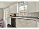 Modern kitchen featuring white cabinets, hardwood floors, a garden window, and stainless steel appliances at 73 11Th Nw St, Carmel, IN 46032