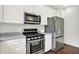 Modern kitchen featuring stainless steel appliances, white cabinets, and hardwood floors for a sleek look at 73 11Th Nw St, Carmel, IN 46032