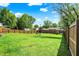 The large, fenced backyard boasts a well-maintained lawn and mature trees, perfect for outdoor activities and relaxation at 7437 Lorene Ct, Indianapolis, IN 46237