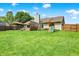 Expansive backyard with a deck, playset, and mature trees, offering ample space for recreation and enjoyment at 7437 Lorene Ct, Indianapolis, IN 46237