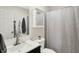 Bathroom with patterned shower curtain, white vanity, and sink, complemented by neutral walls and a well-lit mirror at 7437 Lorene Ct, Indianapolis, IN 46237
