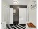 Stylish foyer with black and white checkered floors, decorative mirror, and ample storage at 7437 Lorene Ct, Indianapolis, IN 46237