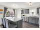 Gray kitchen island with white countertop and bar stool seating near stainless steel appliances at 7437 Lorene Ct, Indianapolis, IN 46237