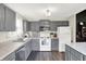 Well-lit kitchen featuring gray cabinets, white appliances, and modern countertops at 7437 Lorene Ct, Indianapolis, IN 46237