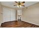 Bedroom with hardwood floors, ceiling fan, double closets, and an open doorway at 7637 Sand Run Ct, Indianapolis, IN 46259