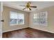 An empty bedroom featuring two windows, wood floors, and a ceiling fan with lighting at 7637 Sand Run Ct, Indianapolis, IN 46259