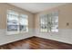 Well-lit dining room featuring wood floors, wainscoting, and two large windows at 7637 Sand Run Ct, Indianapolis, IN 46259