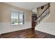 Bright and spacious living room featuring wood floors, wainscoting, and staircase at 7637 Sand Run Ct, Indianapolis, IN 46259