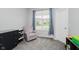 Comfortable bedroom showcasing a cozy armchair, soft carpet, and natural light from the window at 7724 Dunleer Dr, Brownsburg, IN 46112