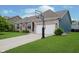 Inviting brick home with a well-manicured lawn, attached two-car garage, and a basketball hoop in the driveway at 7724 Dunleer Dr, Brownsburg, IN 46112