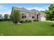 Landscaped front yard showcasing lush green grass, flowering bushes, and a brick home at 7724 Dunleer Dr, Brownsburg, IN 46112