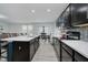 Modern kitchen features dark cabinetry, stainless steel appliances, and a large center island with bar seating at 7724 Dunleer Dr, Brownsburg, IN 46112